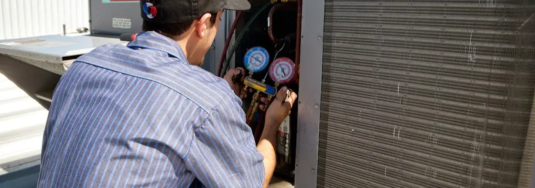 HVAC technician servicing a condenser unit in Edgewater Park